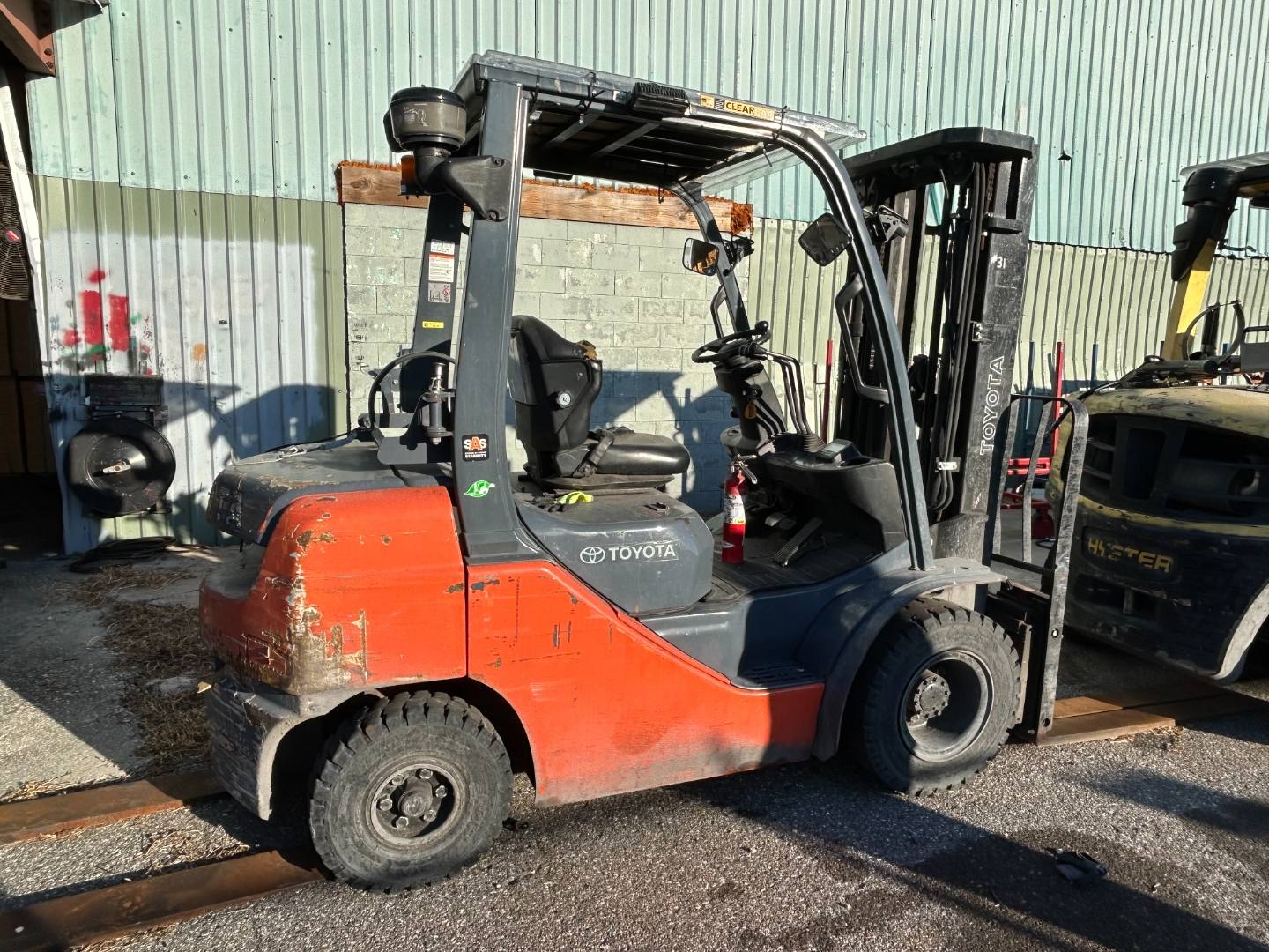 Orange Toyota warehouse forklift parked outside a building