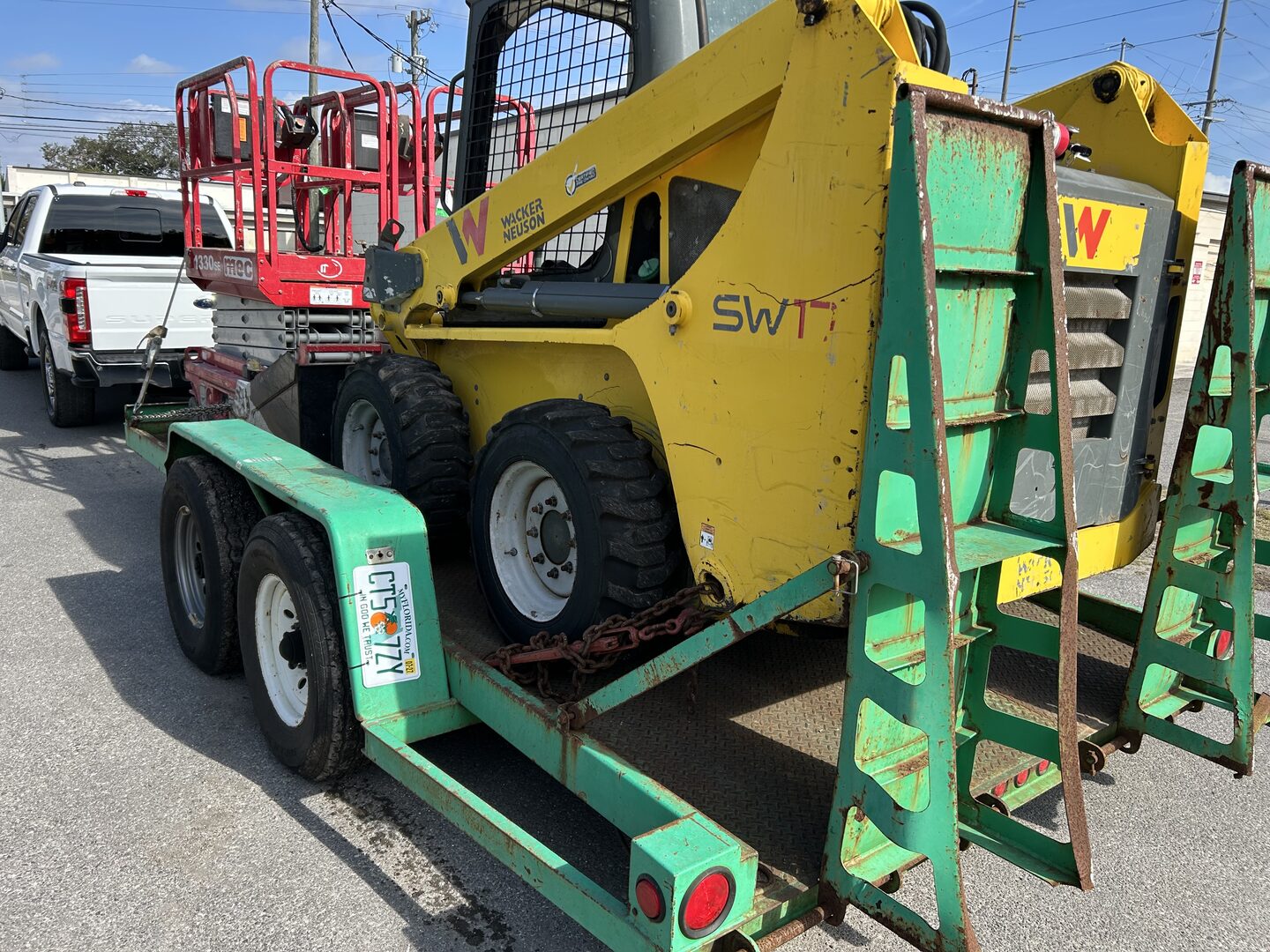 Telehandler reach forklift staged on a trailer at an equipment yard