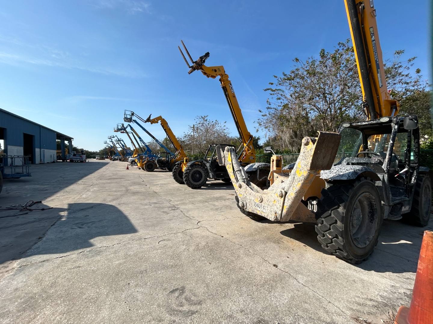 Row of telehandlers and lift equipment at a Central Florida equipment yard