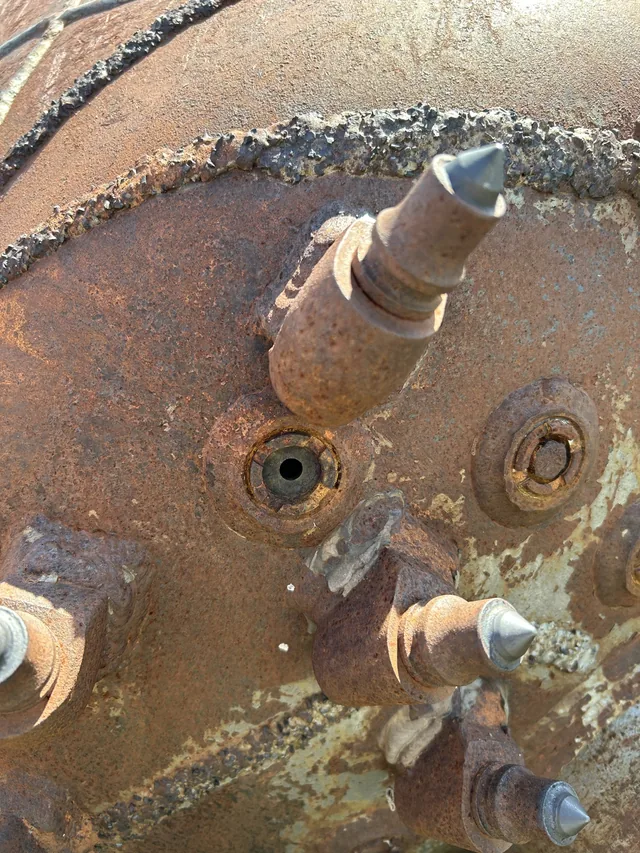 Close-up of cutting picks on a steel drilling head