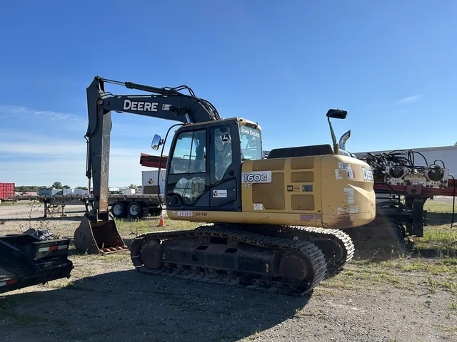 John Deere tracked excavator beside the shop