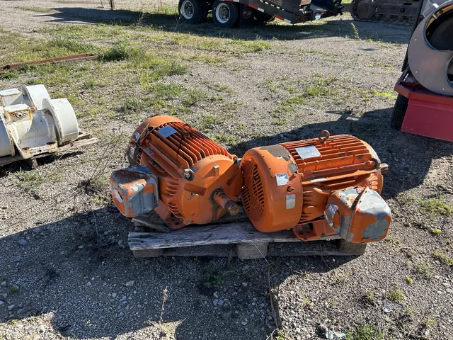 Two orange industrial vibrator motors on a pallet